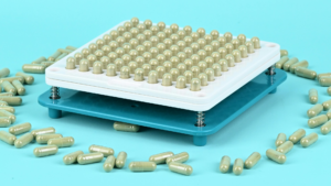 Capsule filling machine tray loaded with capsules for a Canada supplement production run