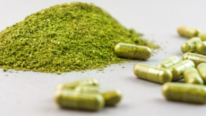 Close-up of kratom powder and empty capsules