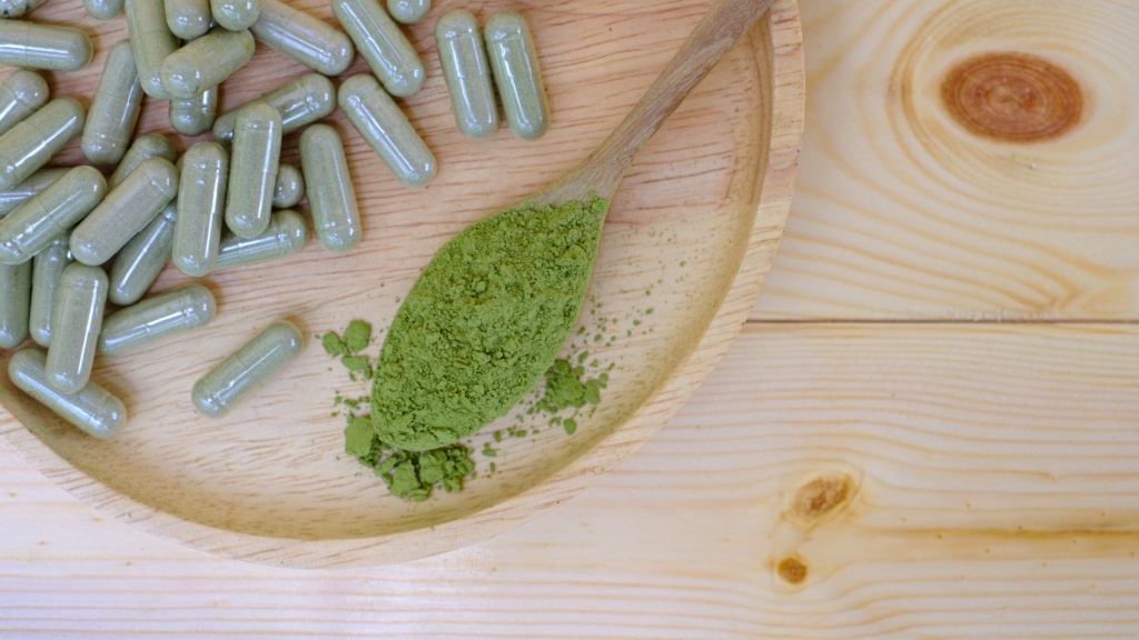 Finished capsules next to a spoon of powder, showing the result of a capsule filling tutorial