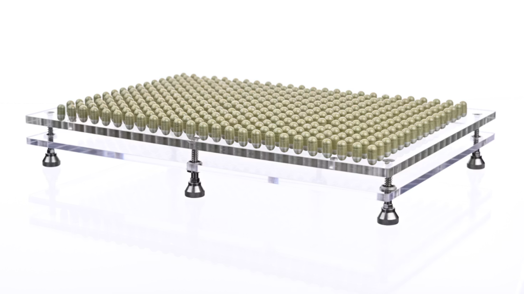 Capsules seated in a precision filling tray mounted on an adjustable-leg base.