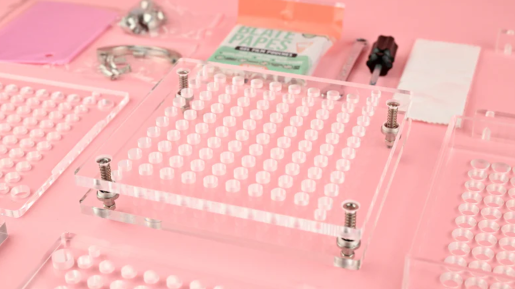 Clear capsule filling machine tray with alignment screws for seating capsules correctly