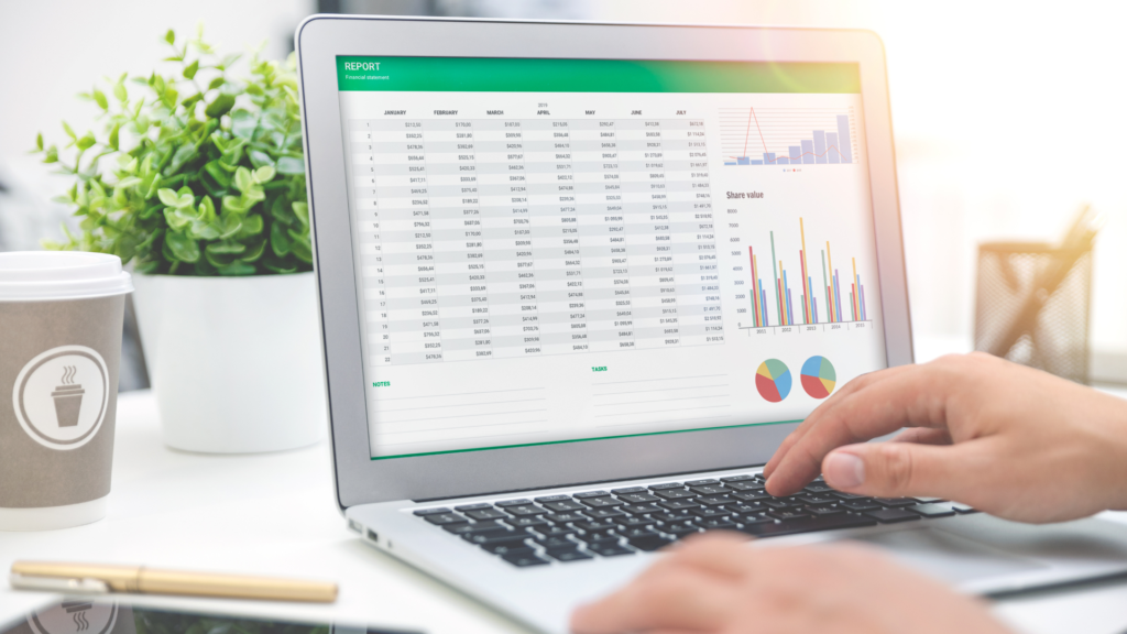 Laptop screen showing financial report and budget charts for a startup.